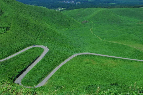 Strada su campo verde in montagna — Foto Stock