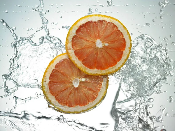 Свежие грейпфрутовые ломтики в воде — стоковое фото