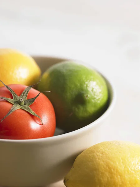 Citrusfrukter och tomat i skål — Stockfoto