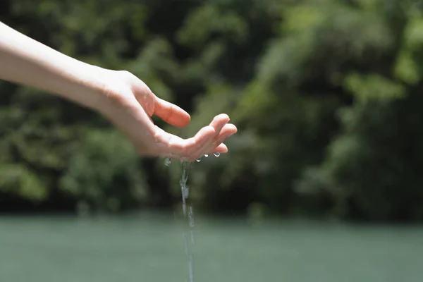 Woman showing hand with falling water