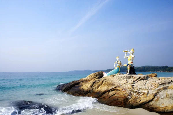 mermaid statues on rocky coast