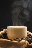 šálek kávy s praženými kávovými zrny