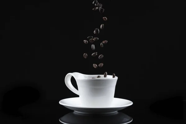 cup with falling coffee beans