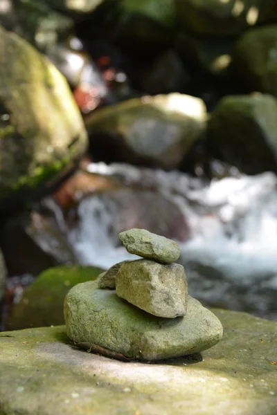 Hög med stenar nära waterfall — Stockfoto