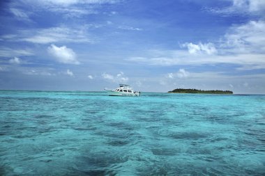 Half Moon Caye Adası ve deniz feneri Reef Atoll güneydoğu köşesinde bulunan Belize doğal anıt yakınındaki beyaz gemi.