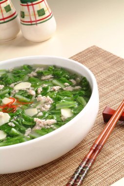 Beyaz lahana çorbası ile kase ve tablo üzerinde et tavuk