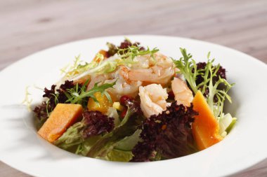 Beyaz plaka portakal, karides ve papaya salatası ile 