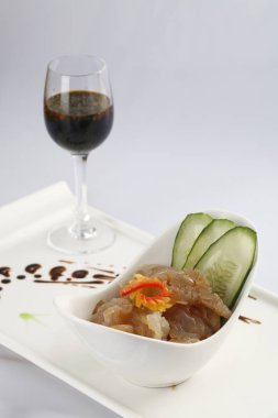 Hazırlanan denizanası ve masada kırmızı şarap ile beyaz plaka