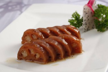 Tabak pişmiş lotus kökleri ile closeup. Geleneksel Çin yemeği