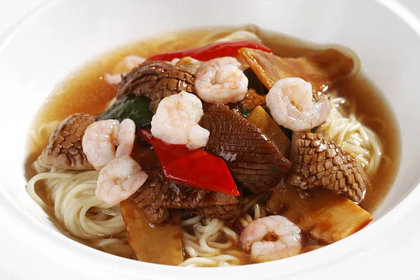 Bowl of seafood noodle soup on kitchen table