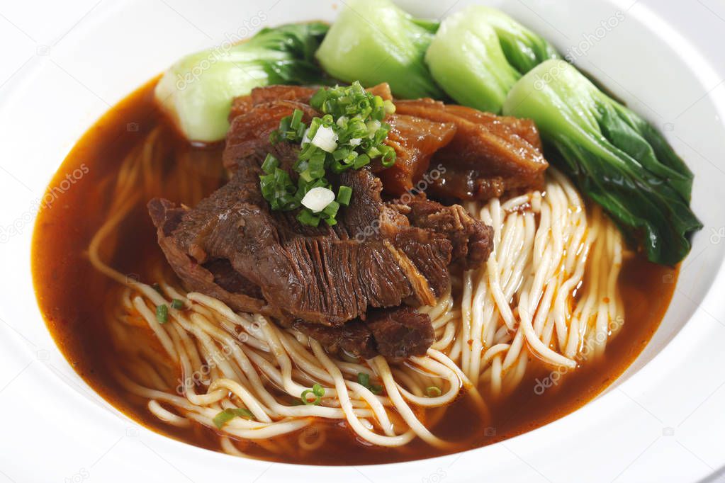 Closeup of bowl with beef noodle soup on table