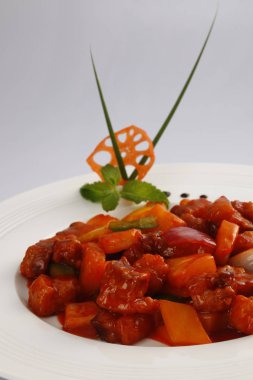 Tatlı tatlı ve ekşi domuz eti beyaz dekore edilmiş plaka üzerinde 