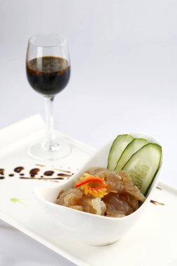 Hazırlanan denizanası ve masada kırmızı şarap ile beyaz plaka