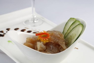 Hazırlanan denizanası ve masada kırmızı şarap ile beyaz plaka