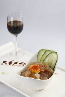 Hazırlanan denizanası ve masada kırmızı şarap ile beyaz plaka