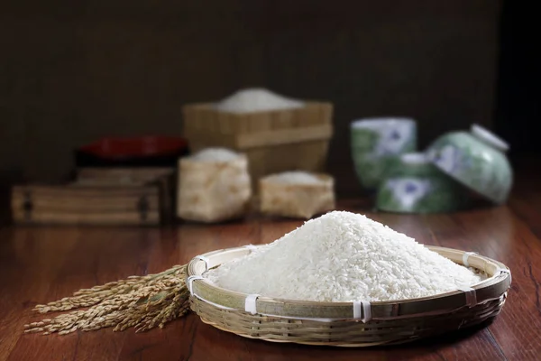 Pile of raw rice over wooden background