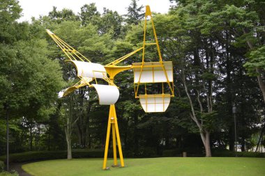 Yeşil parkta sarı ve beyaz heykel