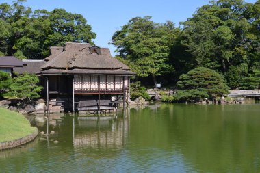 Asyalı kulübesi ve ağaçları olan göl.