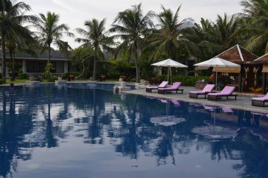 Güverte sandalyeli ve şemsiyeli yüzme havuzu