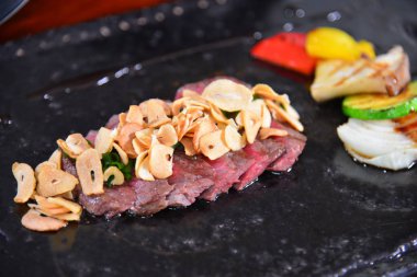 Dilimlenmiş sarımsak ve sebzeli sığır eti.