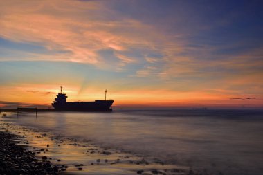 Karanlık çöktüğünde gemi siluetiyle deniz manzarası