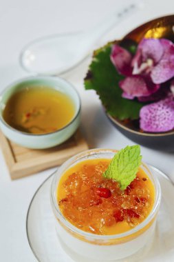 Çay ve çiçeklerle servis edilen tatlı.