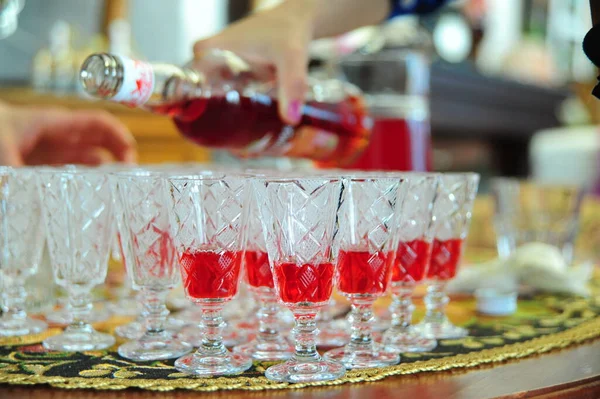 Tasses en verre en rangées avec boisson rouge — Photo