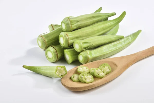 Okra en gesneden okra op de houten lepel op de witte achtergrond — Stockfoto