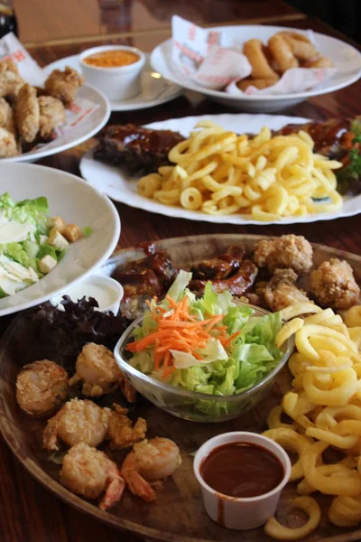 Varios alimentos servidos en los platos de madera sobre la mesa — Foto de Stock