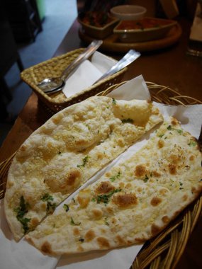 Hasır tabakta servis edilen naan yemeği.