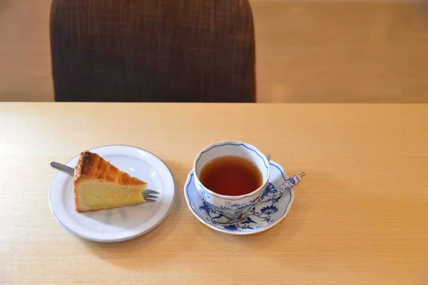 Arrangement Sliced cheese cake and black tea on the wooden table — ストック写真