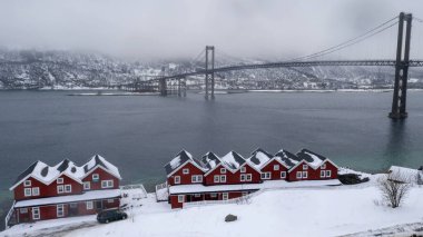 Norveç, Evenskjer belediyesinde kışın kırmızı evler ve köprü manzarası.