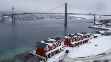 Norveç, Evenskjer belediyesinde kışın kırmızı evler ve köprü manzarası.