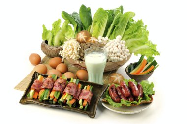 Beyaz arka planda tabakta çeşitli yemekler servis ediliyor.