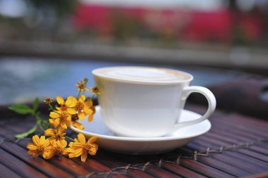 Tahta masada beyaz kupa var.