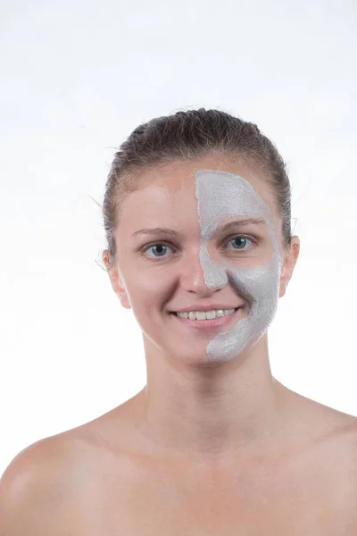 Kosmetiska mask av grå lera med skrubba ansiktet en unga gir — Stockfoto
