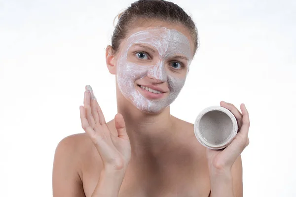 Dos máscara cosmética de arcilla gris con exfoliante y crema en la cara —  Fotos de Stock