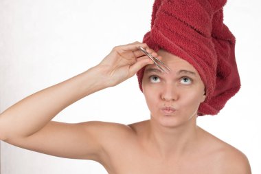 Genç kız cımbız metal bir beyaz üzerine kaşlarını ortaya çıkarır