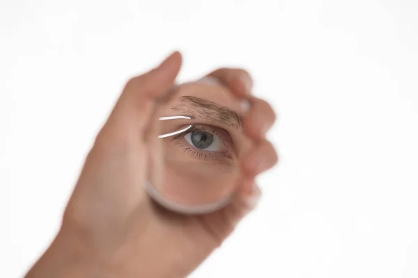 Junges Mädchen zieht ihre Augenbrauen mit einer Pinzette Metall auf einem weißen — Stockfoto