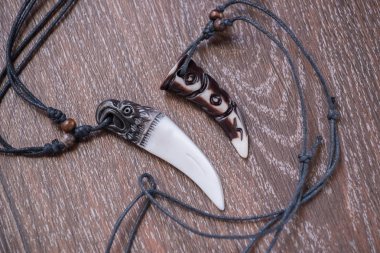 Geyik kahverengi bir bac üzerinde gelen büyük ayı diş ve kemik kolye oyulmuş