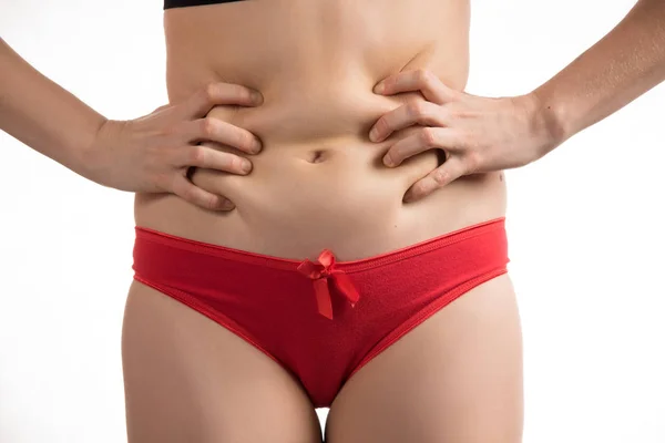 A menina em uma roupa interior vermelha para tocar a gordura em seu estômago e — Fotografia de Stock