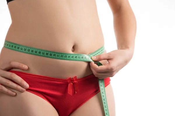 Девушка на диете измерения талии и живота сантиметра и выглядит — стоковое фото