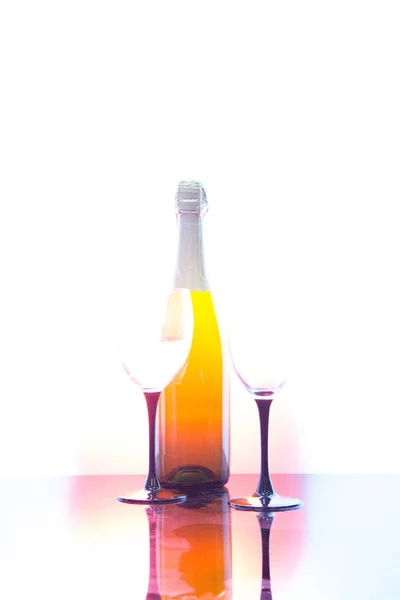 Gelas sampanye dan sebotol anggur dengan latar belakang hitam — Stok Foto