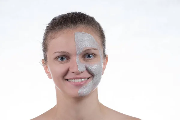 Mascarilla cosmética de arcilla gris con exfoliante en la cara de una joven gir —  Fotos de Stock