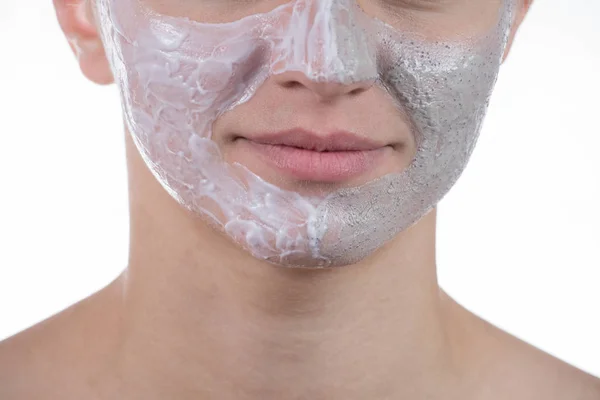 Två kosmetiska mask av grå lera med scrub och kräm i ansiktet — Stockfoto