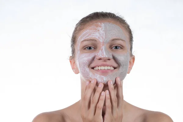 Dos máscara cosmética de arcilla gris con exfoliante y crema en la cara —  Fotos de Stock