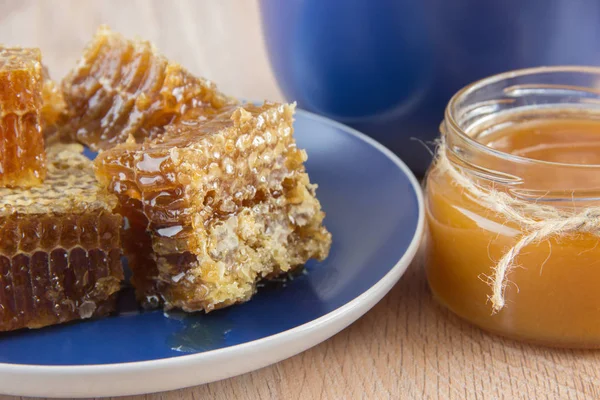 Trozos de panal de miel en una mesa con té, limón y canela —  Fotos de Stock