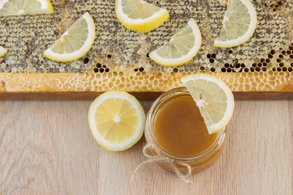 Золотий мед у гребінці в банці та жовтому лимоні — стокове фото