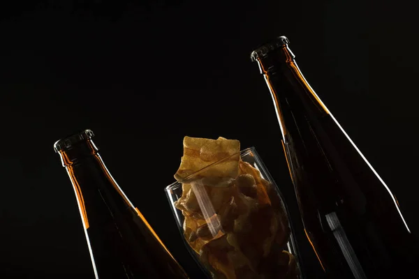 Birra d'oro in bottiglia e in un bicchiere e snack noci, calamari e — Foto Stock