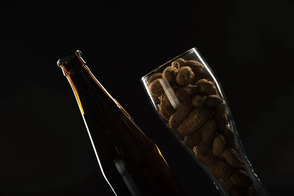 Cerveja dourada em uma garrafa e em um copo e lanche nozes, lulas e — Fotografia de Stock